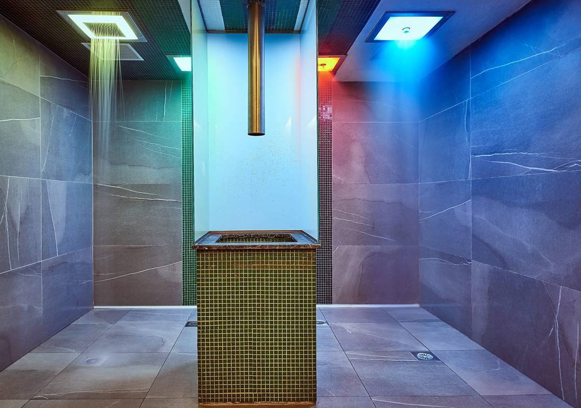 Dusche im Mayia Exclusive Resort & Spa mit farbigen Lichtern und Marmorfliesen.
