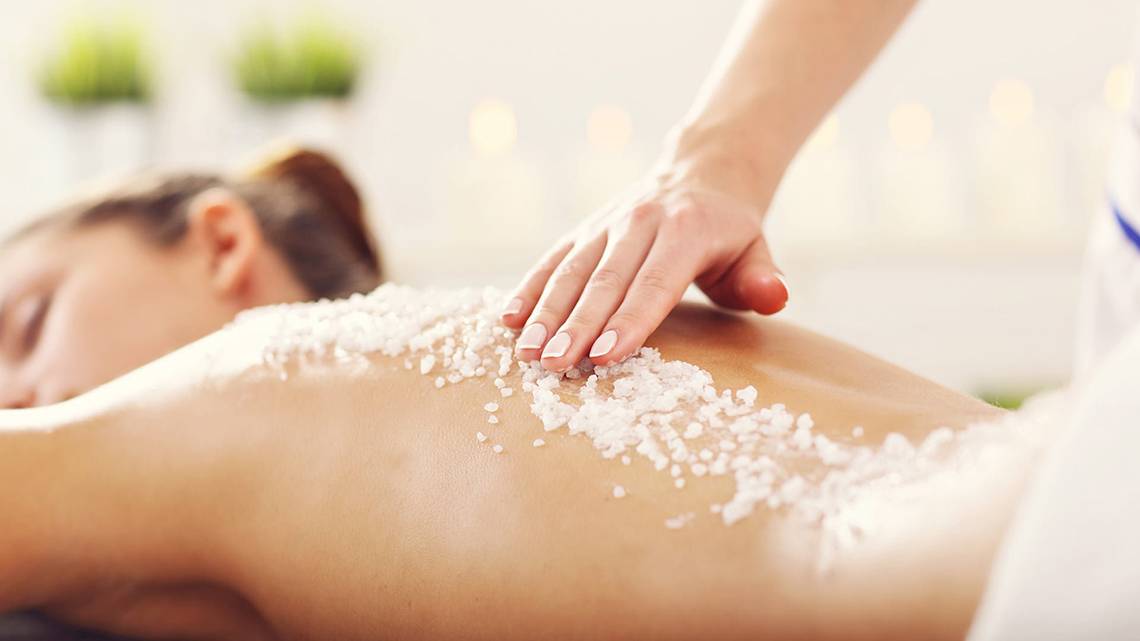 Eine Frau im Mayia Exclusive Resort & Spa erhält eine Salzmassage auf ihrem Rücken.