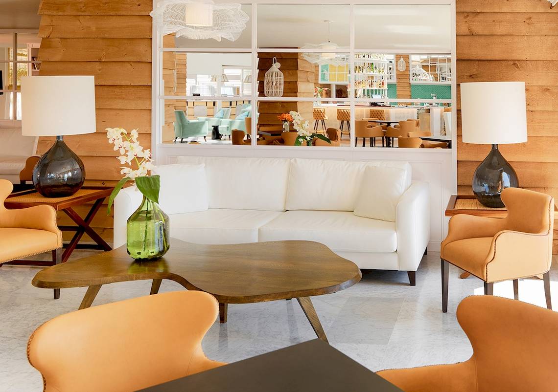 Lobbybereich des H10 Playa Esmeralda Hotels mit weißem Sofa und dekorativen Lampen.