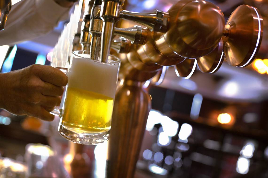 Eine Person zapft Bier in einem Glas im Park Rotana Abu Dhabi.