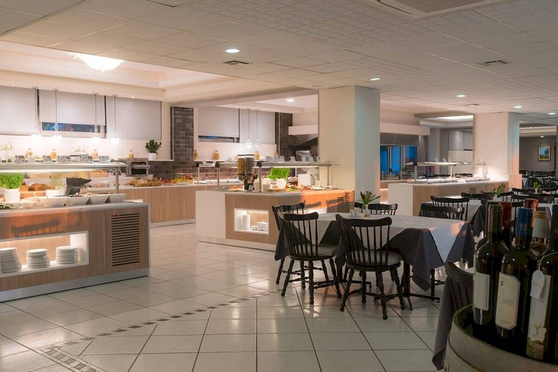 Frühstücksraum im Elea Beach Hotel mit Tischen, Stühlen und Buffet.