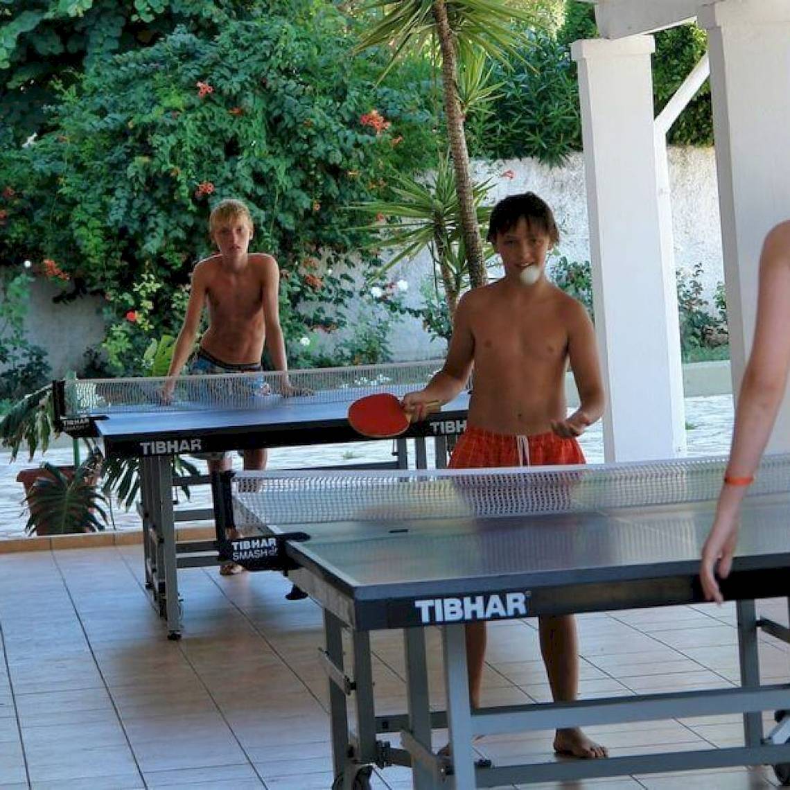 Junge spielen Tischtennis im Freien im Hotel Elea Beach.