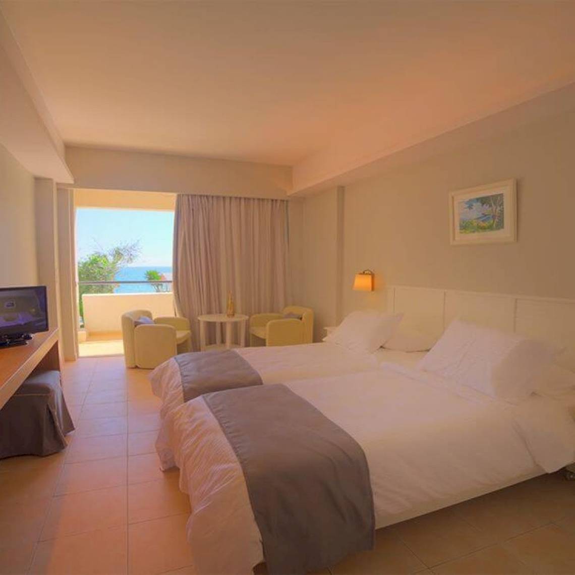 Zimmer im Elea Beach Hotel mit zwei Betten und Meerblick.