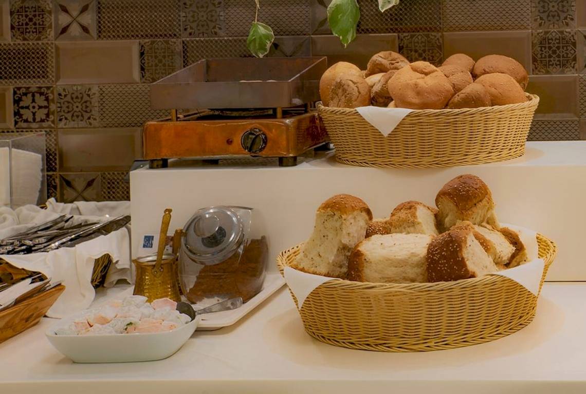 Frühstücksbuffet im Elea Beach Hotel mit Brotkörben, Toaster und Gebäck.