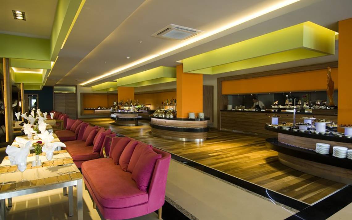 Innenansicht des Restaurants im Casa De Maris Spa & Resort mit Holzboden und pinken Sofas.