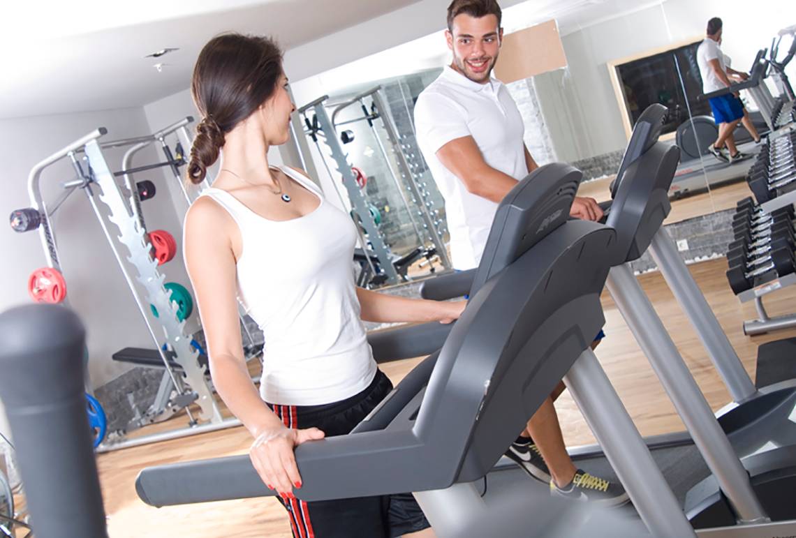 Mann und Frau im Fitnessstudio auf einem Laufband trainieren