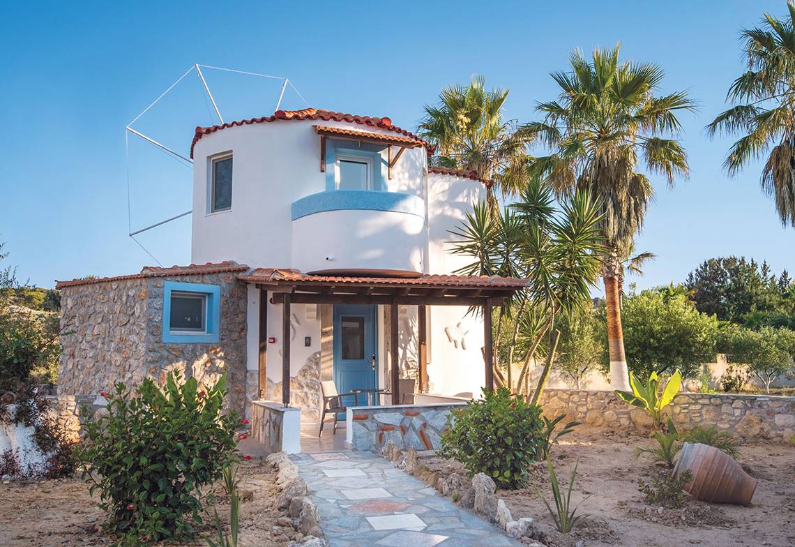 Außenansicht der Eurovillage Achilleas Villa mit Steinmauern und Palmen