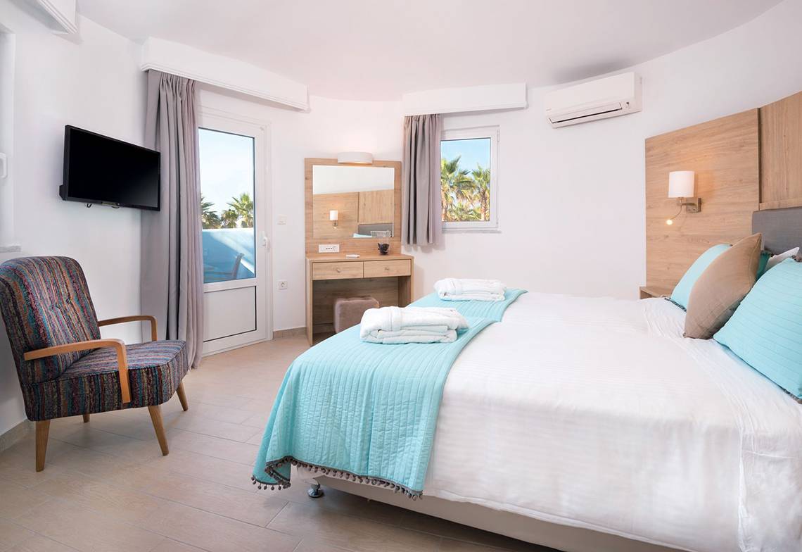 Schlafzimmer im Eurovillage Achilleas Hotel mit Doppelbett, Fernseher und Klimaanlage.