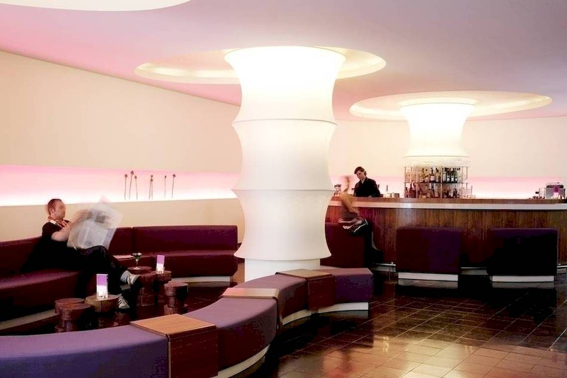 Lobbybereich des Ku Damm 101 Hotels mit Sitzbereichen und Bar.