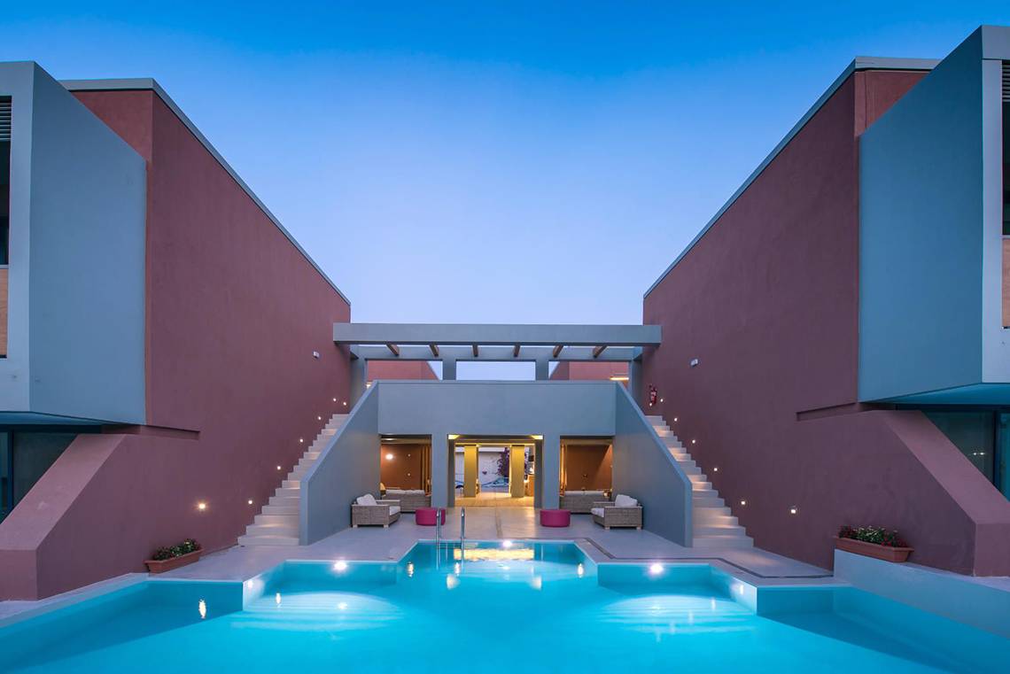 Nachtansicht des Poolbereichs im Corissia Princess Hotel mit beleuchteten Treppen und Möbeln.