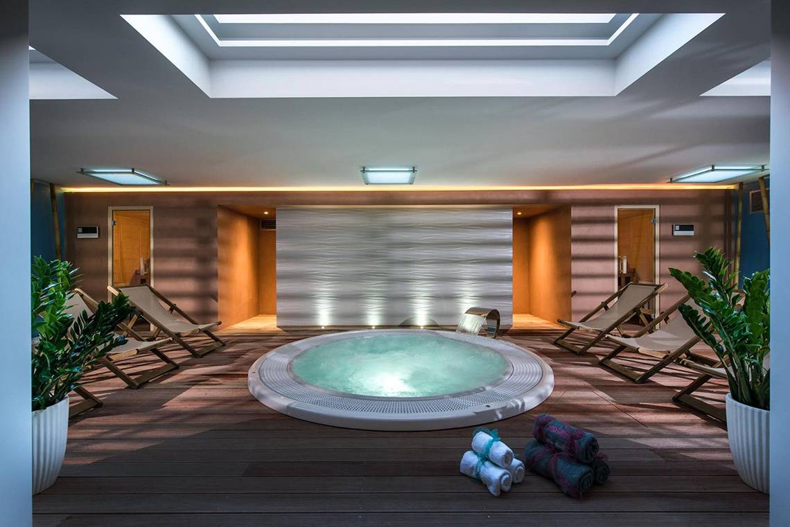 Jacuzzi-Bereich im Corissia Princess Hotel mit Lounge-Stühlen und Pflanzen.