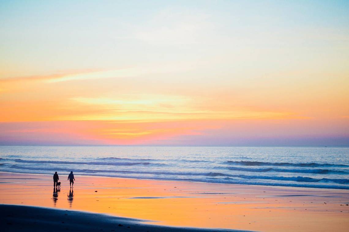 Zwei Leute auf dem Strand bei Sonnenuntergang