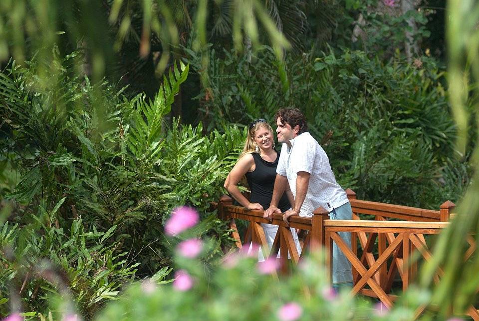 Paar auf Holzbrücke im grünen Garten des Pinewood Beach Resort & Spa