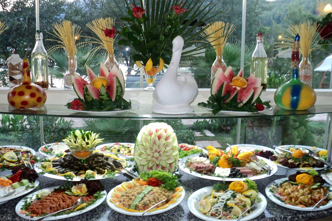 Buffet-Tisch im Dalyan Resort Hotel mit verschiedenen Gerichten und dekorativen Wassermelonen-Skulpturen.