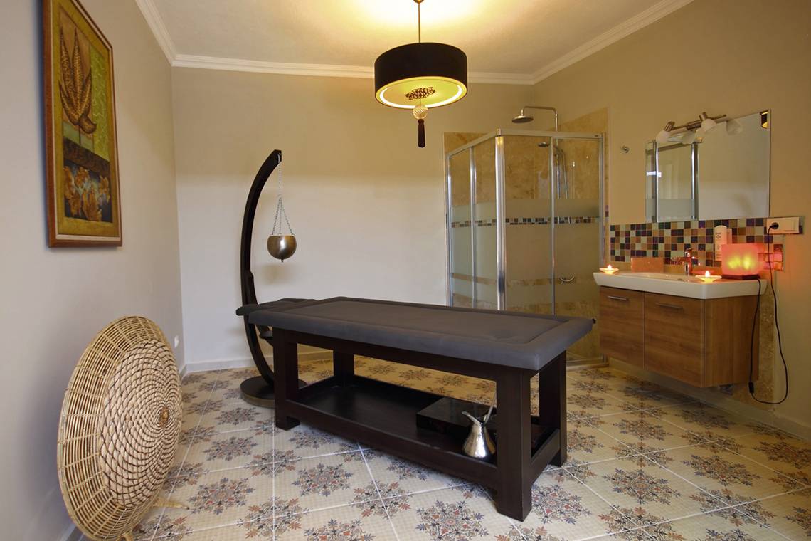 Spa Bereich im Dalyan Resort Hotel mit Massagetisch, Dusche und Waschbecken.