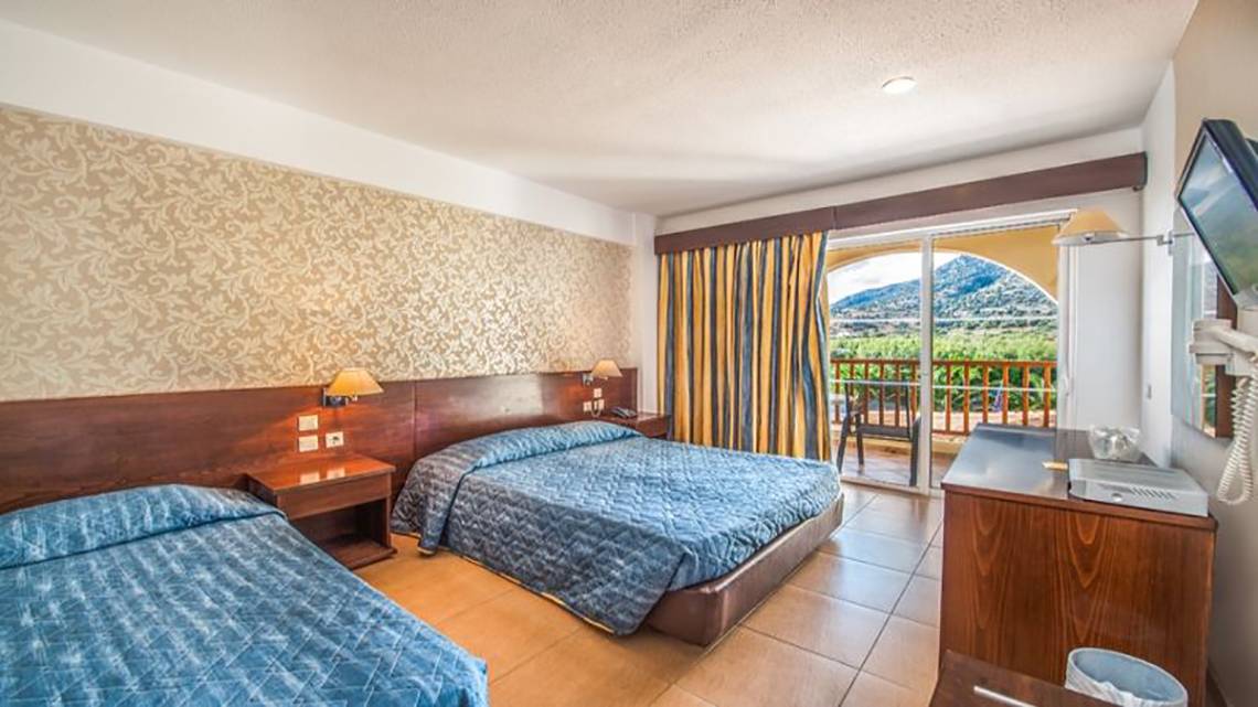 Zwei Betten in einem Hotelzimmer mit einem Balkon und einer Aussicht auf einen Berg.