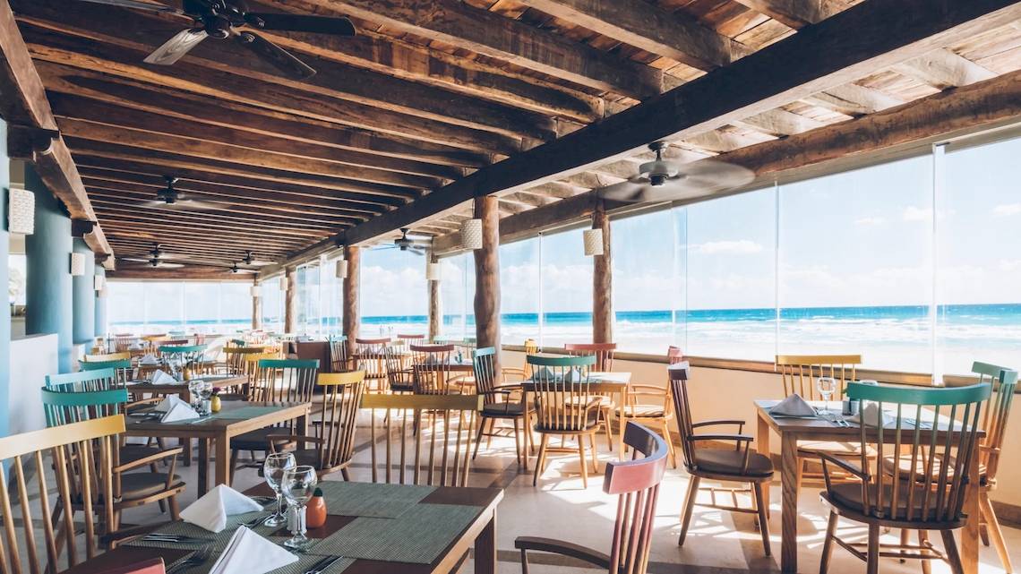 Innenansicht des Restaurants im Iberostar Selection Cancun mit Blick auf den Ozean.