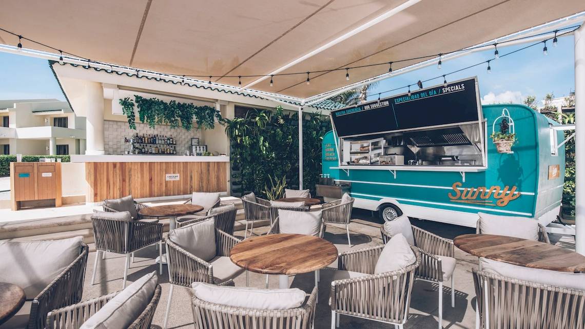 Terrasse des Iberostar Selection Cancun Hotels mit Sitzgelegenheiten und einem Café-Truck.