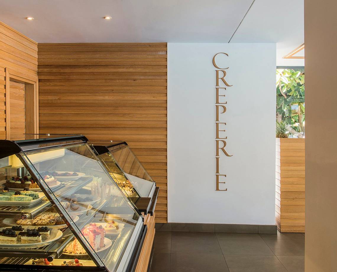 Im Mitsis Grand Hotel Beach zeigt eine Vitrine verschiedene Desserts in einem Café.