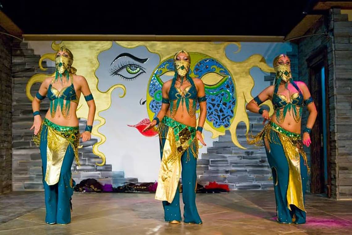 Drei Frauen auf der Bühne mit goldenen Masken und orientalischen Kostümen.