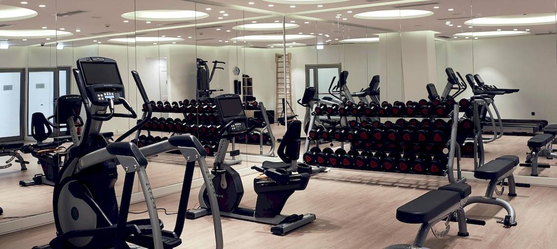 Fitnesscenter im Santo Pure Oia Suites & Villas Hotel mit vielen Geräten und Spiegeln.