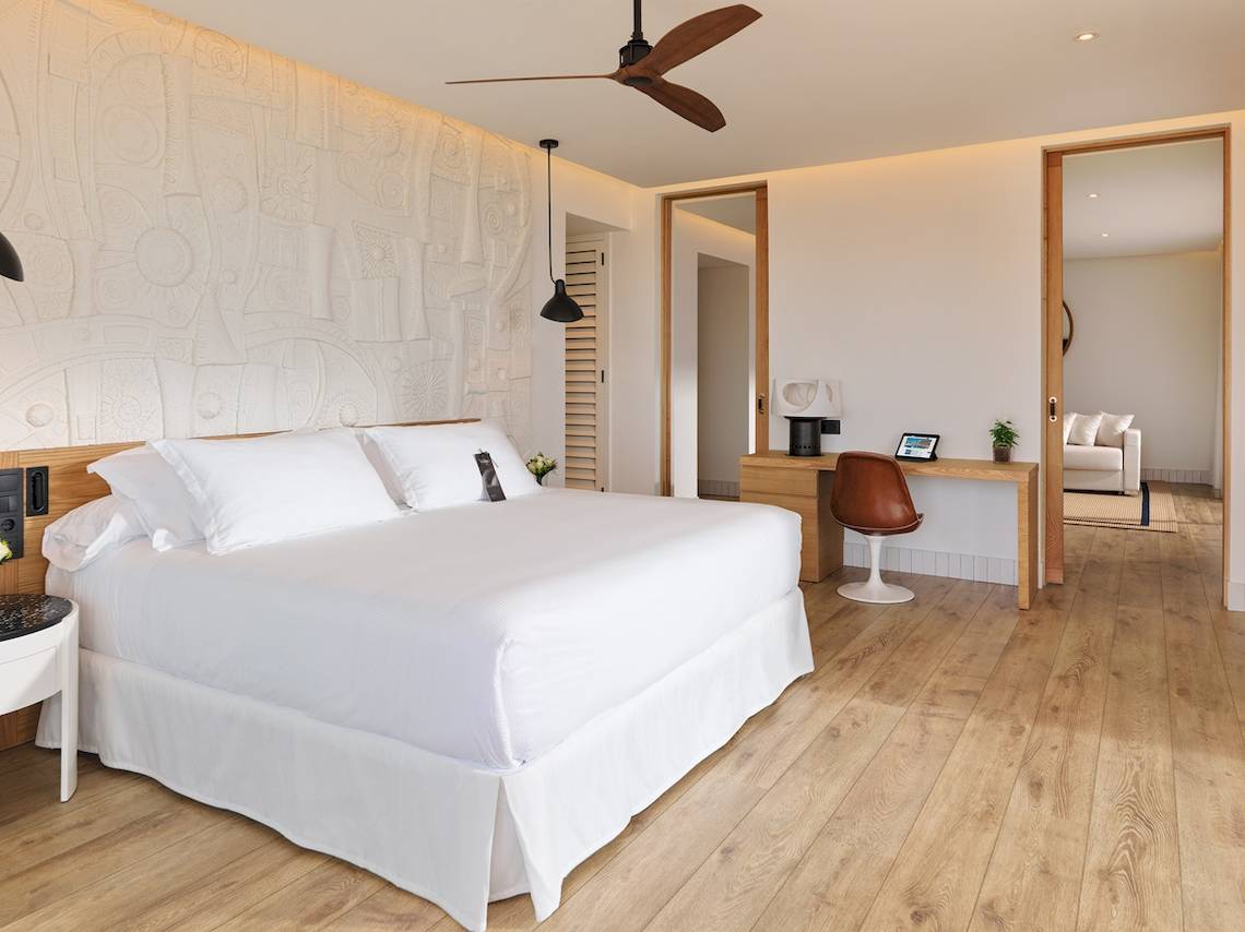 Schlafzimmer im H10 Atlantic Sunset Hotel mit weißem Bett, Holzboden und moderner Einrichtung.