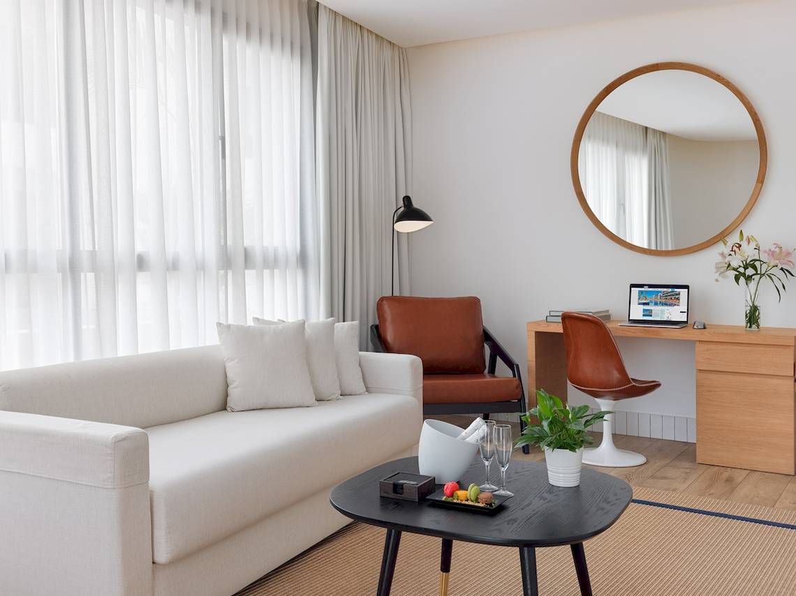 H10 Atlantic Sunset Hotel Innenraum mit Sofa, Schreibtisch und Lampe