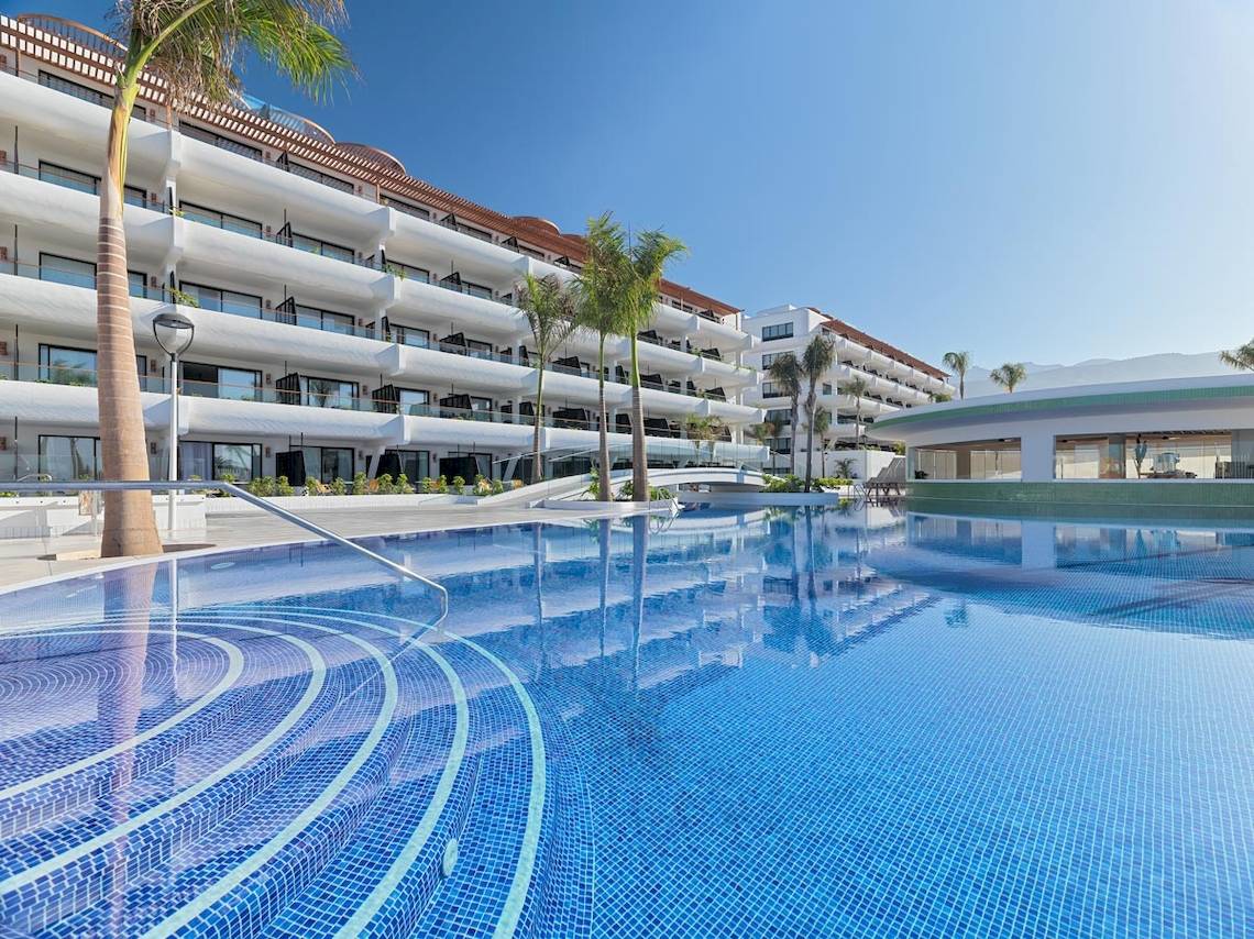 Außenpool des H10 Atlantic Sunset Hotels mit modernem Gebäude im Hintergrund.