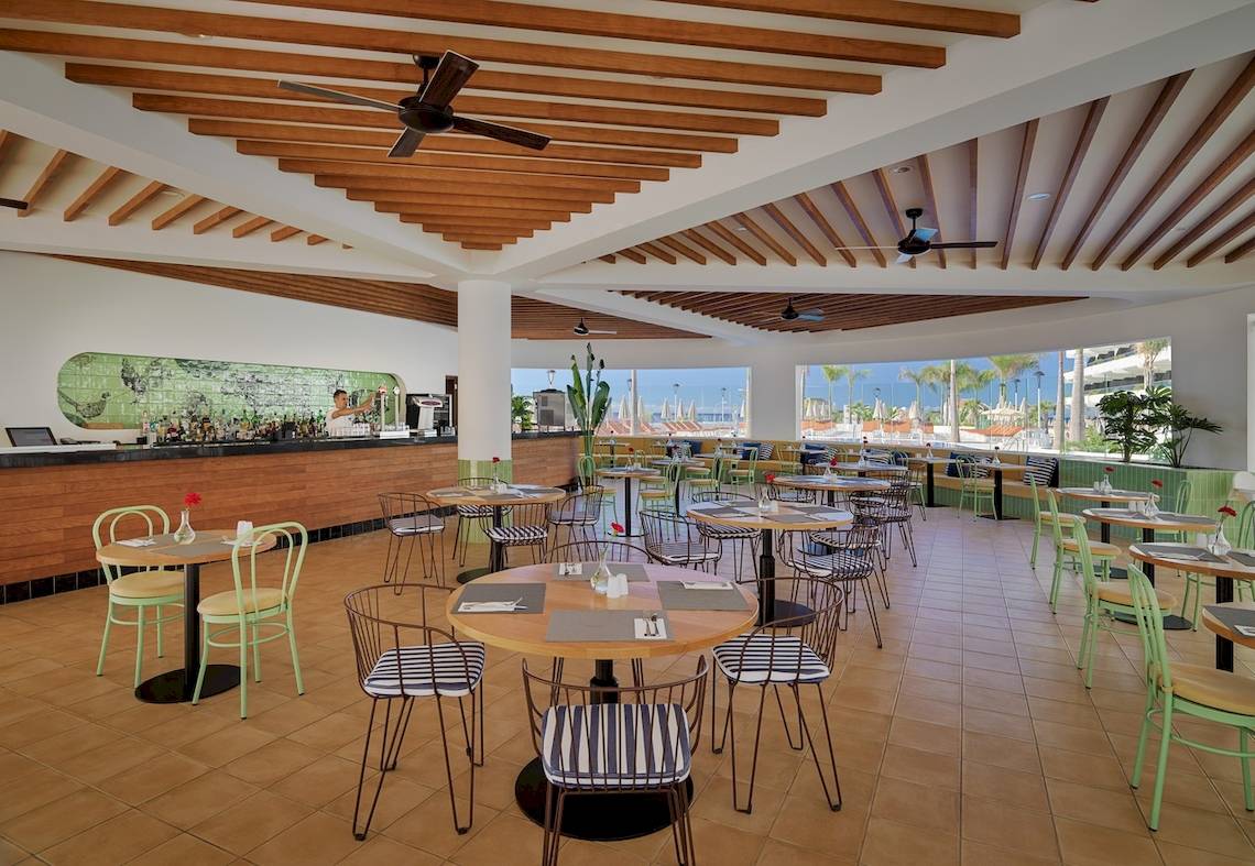 Innenbereich des H10 Atlantic Sunset Hotels mit Bar und Essbereichen.