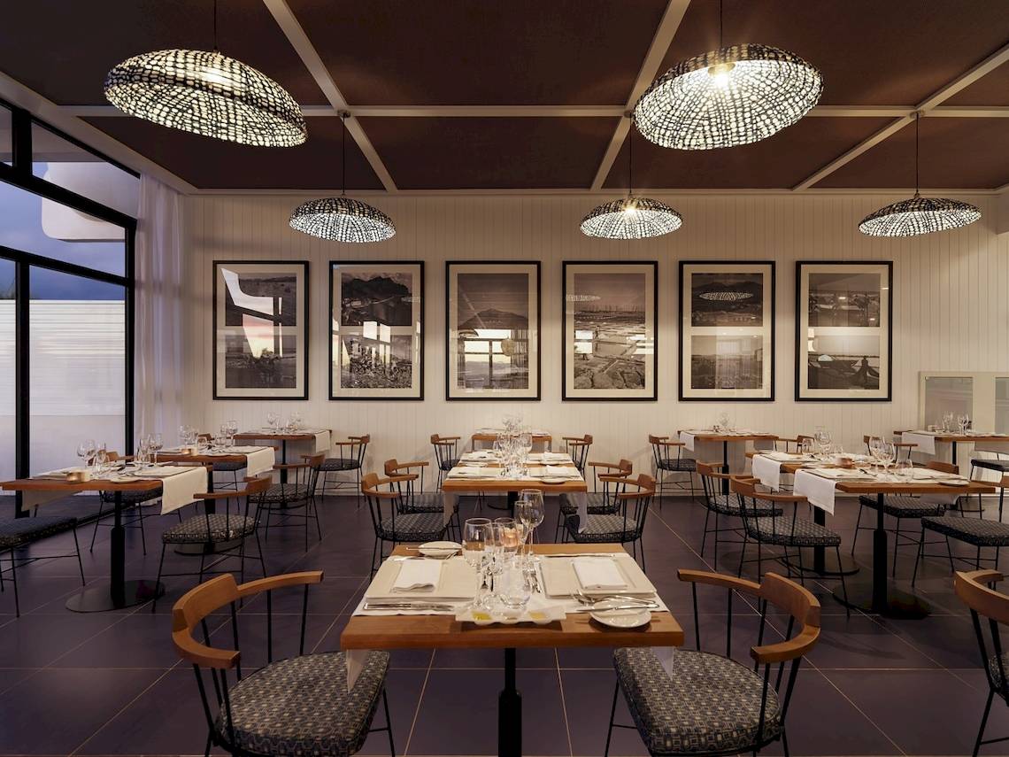 Restaurantbereich des H10 Atlantic Sunset Hotels mit Tisch, Stühlen und Hängelampen.