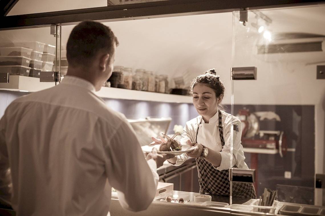 Chef serviciert Kunden im Katikies Chromata Santorini