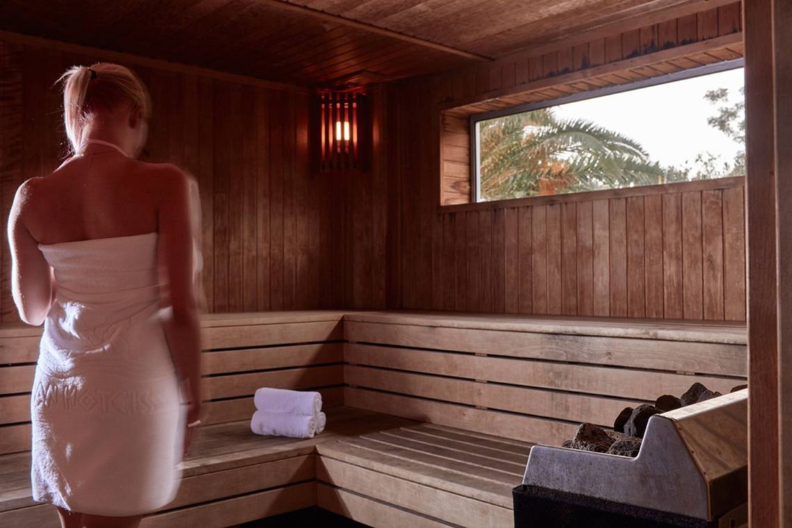 Rückansicht einer Frau in einem weißen Handtuch in der Sauna des Grecian Bay Hotels.