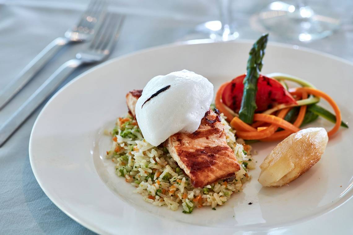 Ein Teller mit gegrilltem Fisch auf Reis im Grecian Bay Hotel.