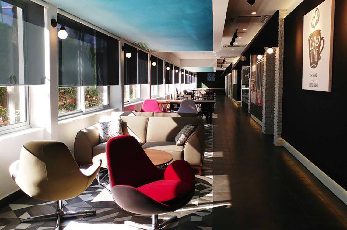 Lobby des Gold Island Hotels mit Sofas, Sesseln und Tischen, hell erleuchtet.