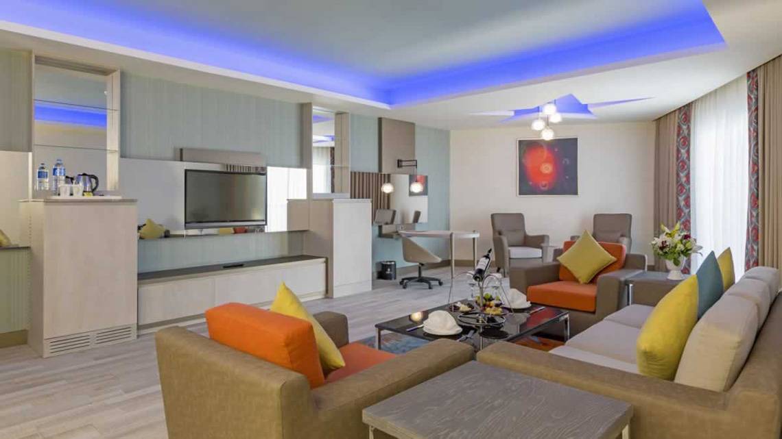 Inneneinrichtung des Royal Seginus Hotels mit Fernseher, Sofas und Tisch