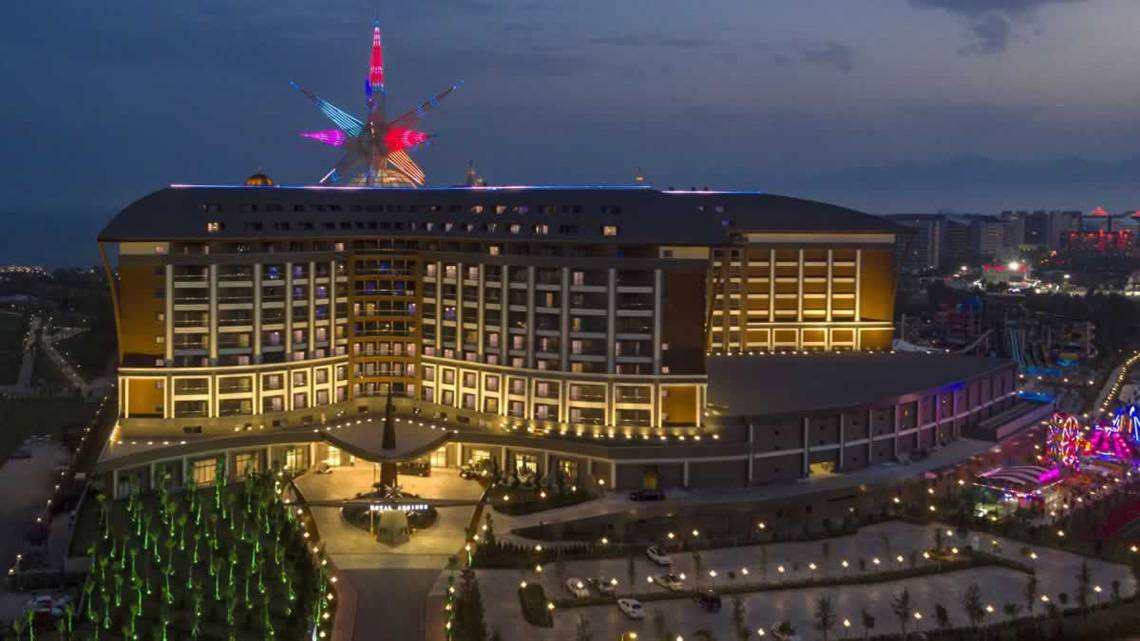 Das Royal Seginus Hotel ist bei Nacht beleuchtet und zeigt eine farbenfrohe Dekoration auf dem Dach.