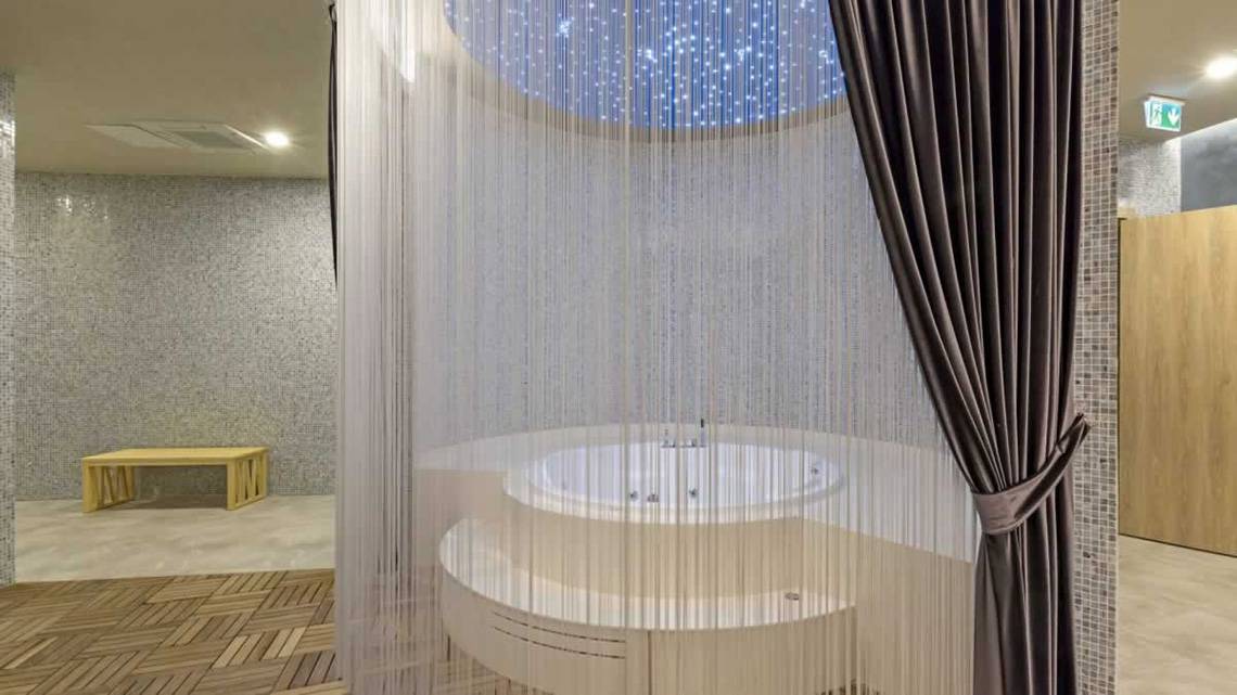Jacuzzi im Wellnessbereich des Royal Seginus Hotels mit Sternenhimmel-Decke und Vorhängen.