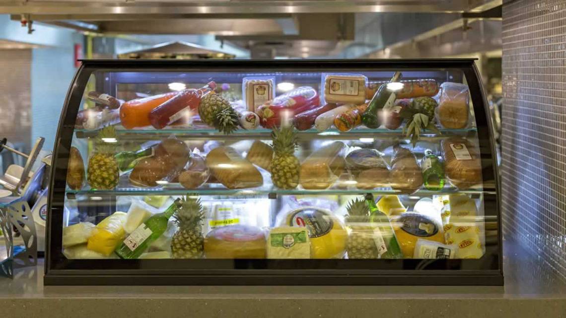 Ein Speiseschrank im Restaurant des Royal Seginus Hotels, gefüllt mit verschiedenen Lebensmitteln wie Brot, Käse, Obst und Getränken.