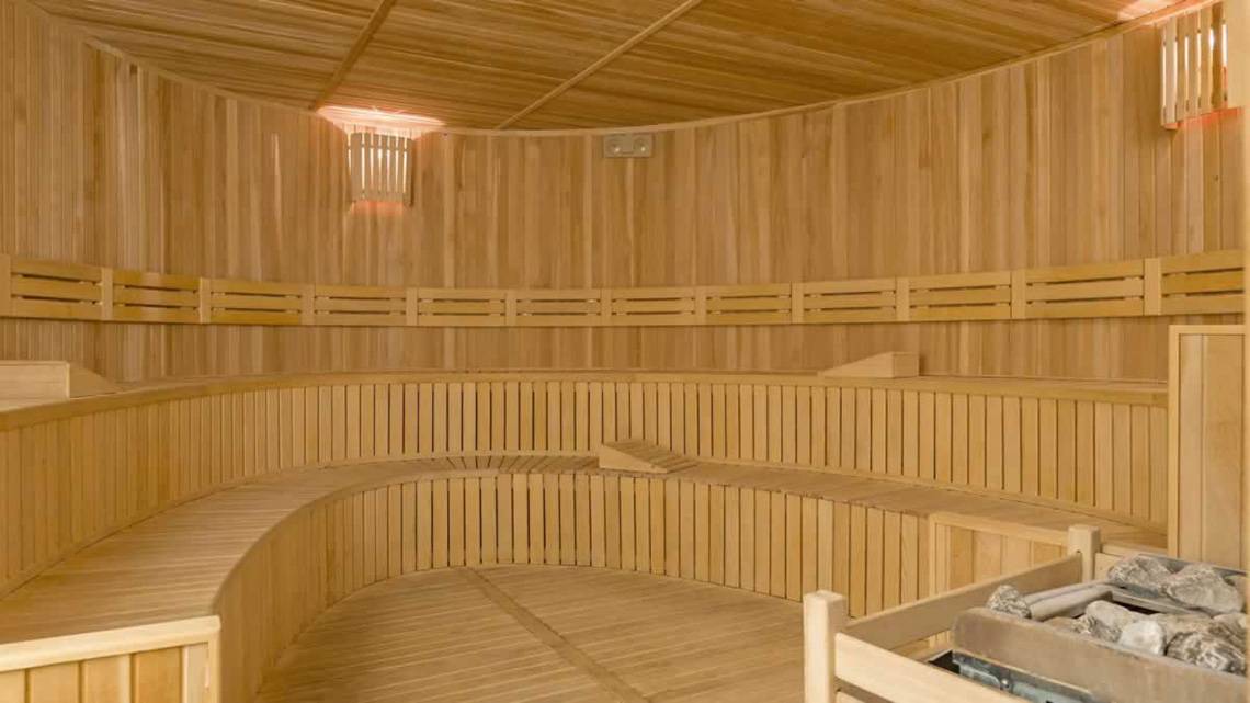 Innenbereich der Sauna im Royal Seginus Hotel mit Holzbänken und einer Lampe.
