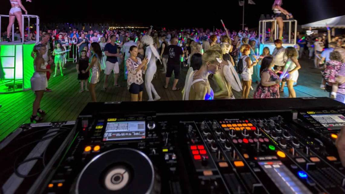 DJ-Event auf der Dachterrasse des Royal Seginus Hotels bei Nacht mit vielen Gästen und bunten Lichtern
