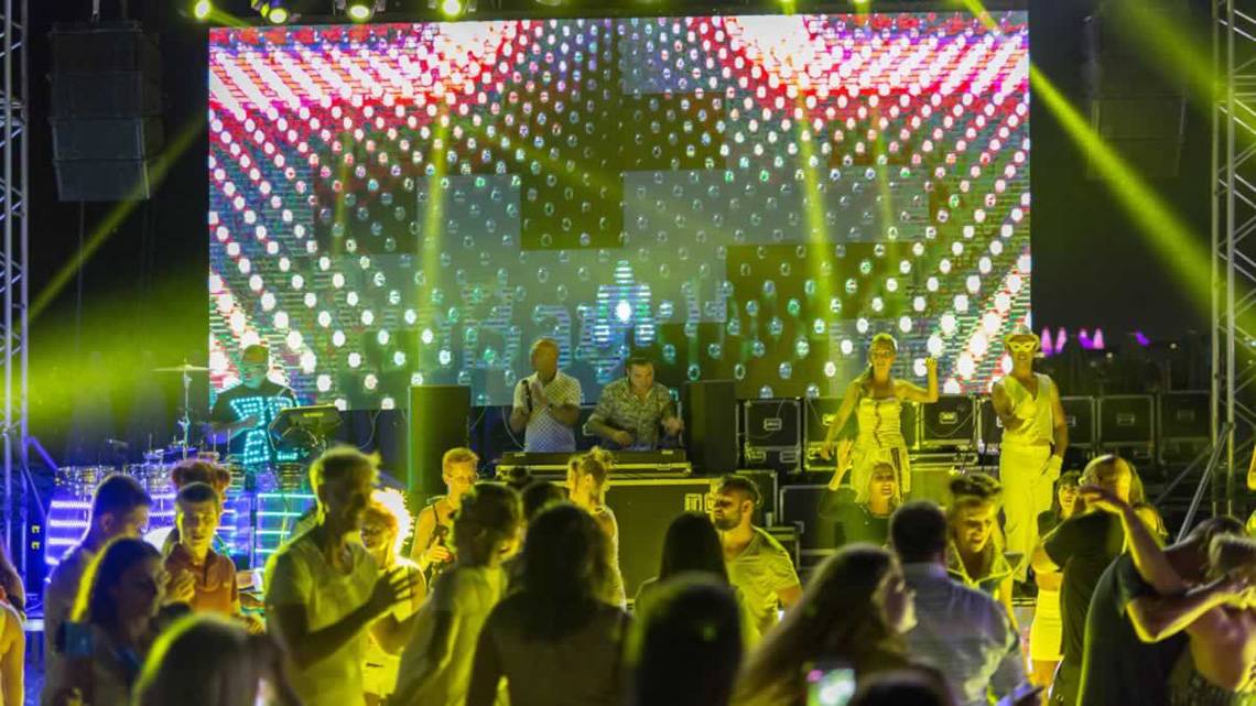 Royal Seginus Hotel mit einer Disco-Veranstaltung auf der Bühne, mit Lichteffekten und einem Publikum.