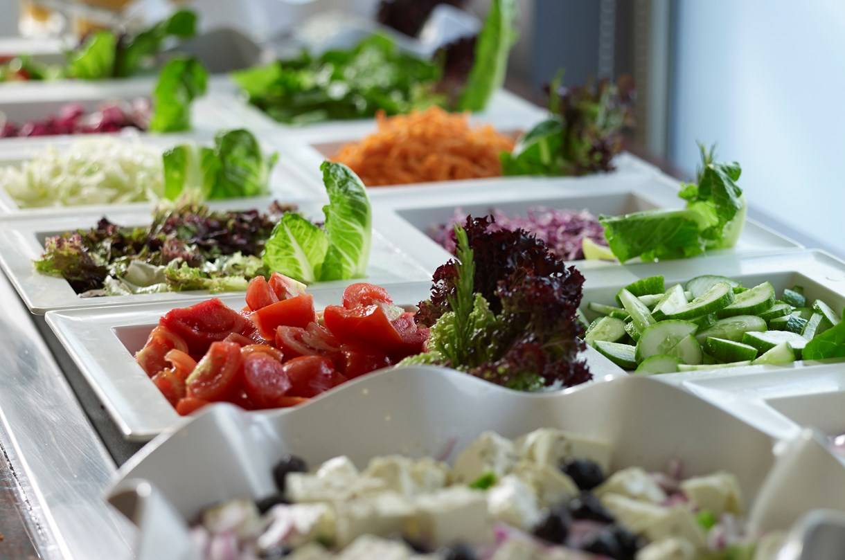 Salatbuffet im Kriti Beach Hotel zeigt verschiedene Salate, Tomaten, Gurken und Oliven.