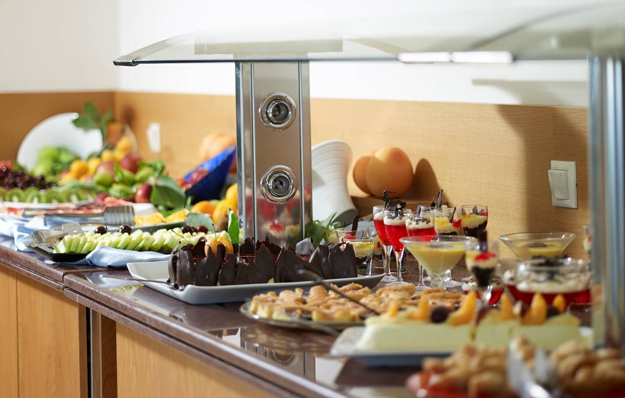 Buffet-Tisch im Kriti Beach Hotel mit einer Auswahl an Früchten, Desserts und Getränken.