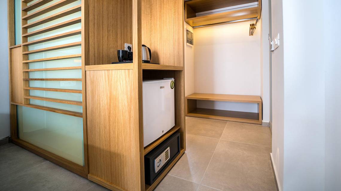 Ein Zimmerschrank im Adele Beach Hotel mit Minibar, Safe und Kaffeemaschine.
