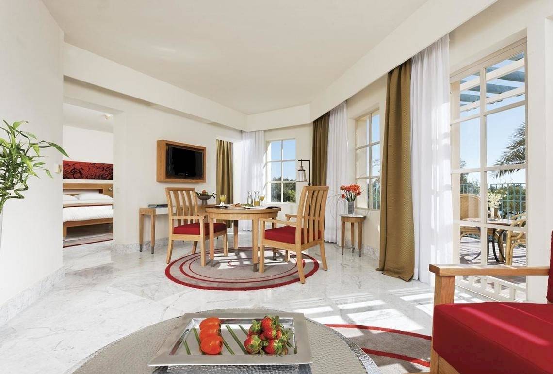 Inneneinrichtung des Mövenpick Resort & Spa El Gouna mit Tisch, Stühlen und Balkon.