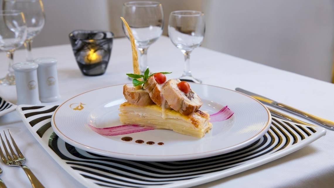 Gedeckter Tisch im Grand Sirenis Riviera Maya Resort & Spa mit einem Gericht aus Fleisch und Gemüse.