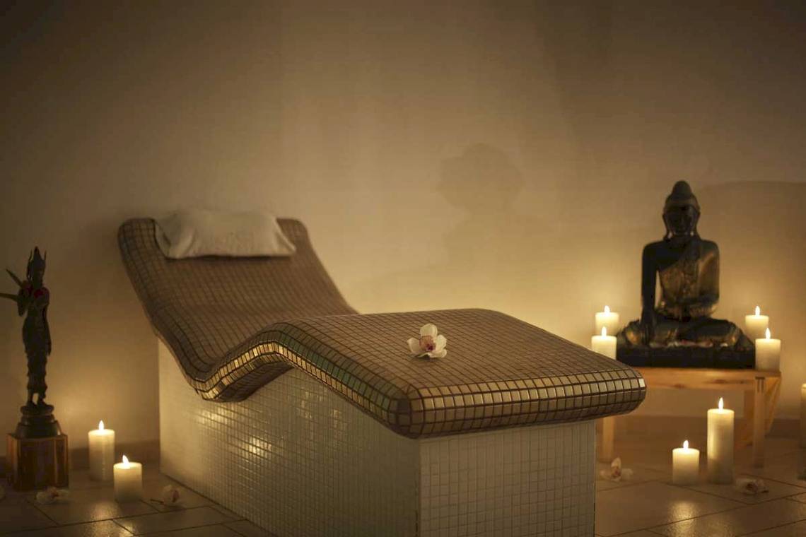 Spa-Lounge im Roca Nivaria Gran Hotel mit Liege, Kerzen und Buddha-Statue.