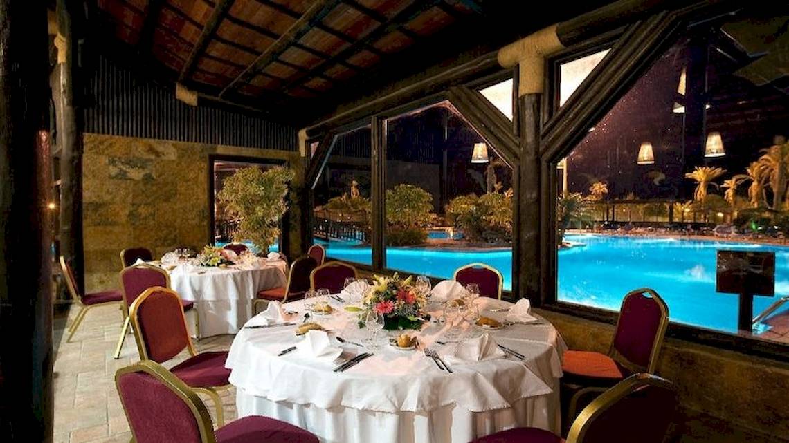 Ein Restaurant im Elba Sara Beach & Golf Resort mit Blick auf den Pool bei Nacht.