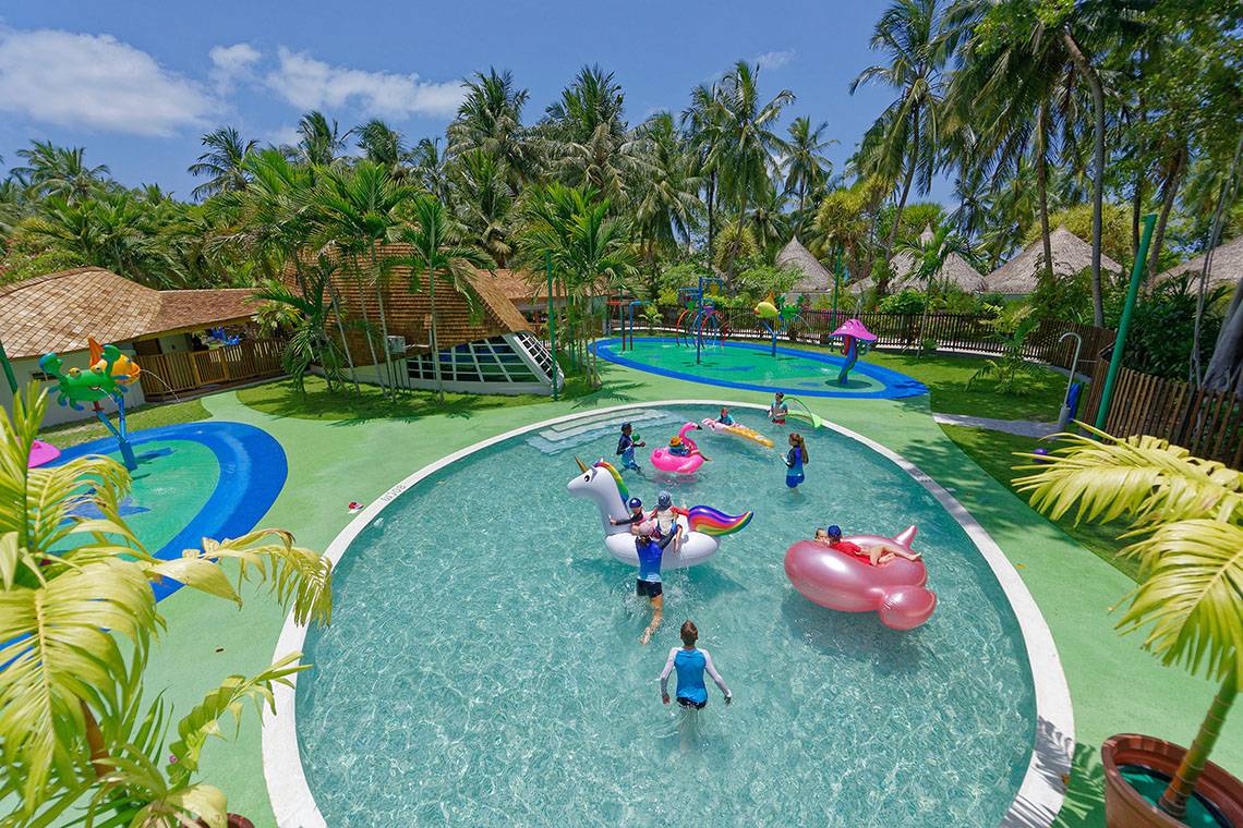 Kuramathi Maldives Außenbereich des Freizeitparks mit Pools, Spielgeräten und Kindern.
