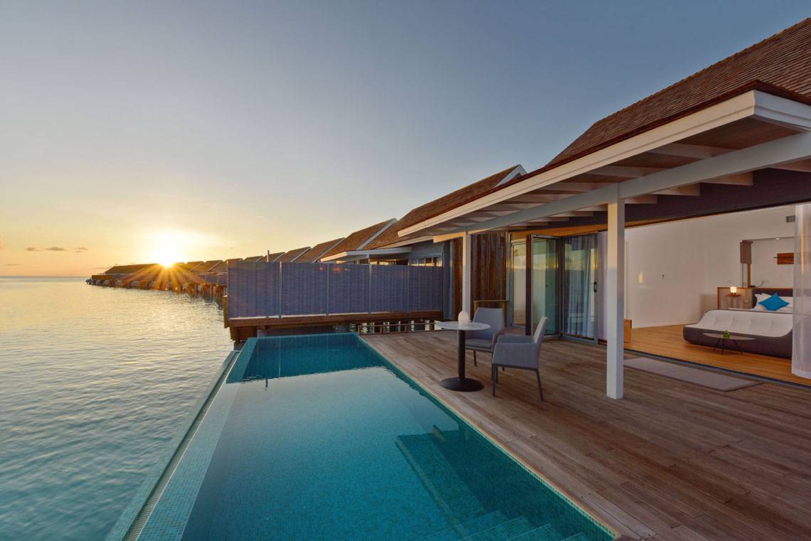 Poolbereich im Kuramathi Maldives Hotel bei Sonnenuntergang